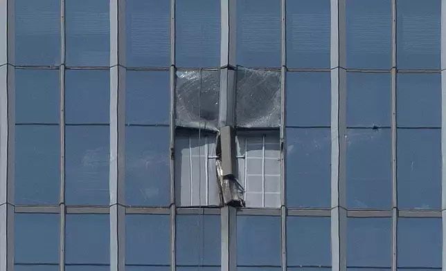 A section damaged after a small plane crashed into it is boarded up at the CITIC Tower, also known as China Zun, the tallest building in Beijing, on Saturday, June 27, 2026. (AP Photo/Ng Han Guan)