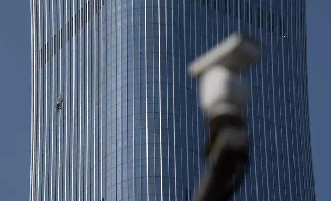 A security camera is seen near a section damaged after a small plane crashed into the CITIC Tower, also known as China Zun, the tallest building in Beijing, on Saturday, June 27, 2026. (AP Photo/Ng Han Guan)