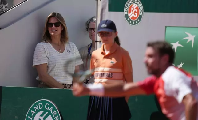Roland Garros tournament director and former tennis star Amelie Mauresmo, left, watches as Stan Wawrinka of Switzerland, right, returns to Jesper De Jong of the Netherlands during their first round men's singles tennis match at the French Open tennis tournament in Paris, Monday, May 25, 2026. (AP Photo/Thibault Camus)