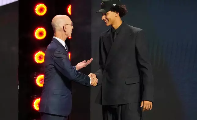 Nate Ament greets NBA Commissioner Adam Silver, left, after being selected by the Milwaukee Bucks as the 13th pick in the first round of the NBA basketball draft, Tuesday, June 23, 2026, in New York. (AP Photo/Yuki Iwamura)