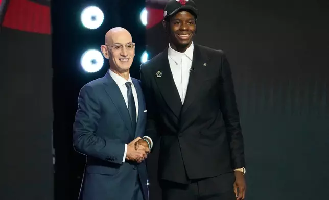 Caleb Wilson, right, poses for a photo with NBA Commissioner Adam Silver, left, after being selected by the Chicago Bulls in the first round of the NBA basketball draft, Tuesday, June 23, 2026, in New York. (AP Photo/Yuki Iwamura)
