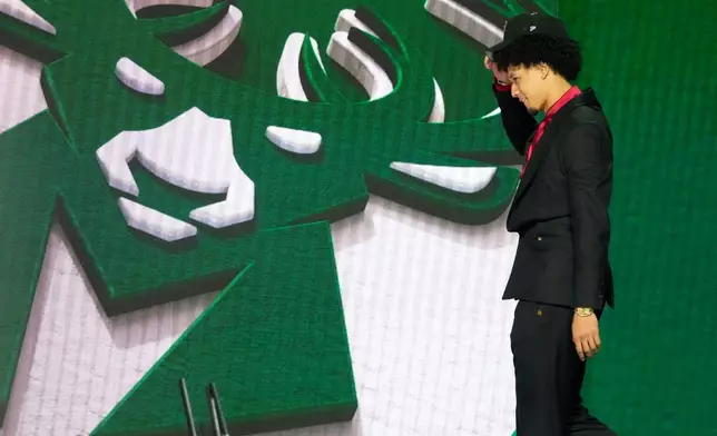 Brayden Burries walks off the stage after being selected by the Milwaukee Bucks as the tenth overall pick in the first round of the NBA basketball draft, Tuesday, June 23, 2026, in New York. (AP Photo/Yuki Iwamura)