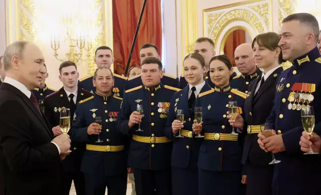 Russian President Vladimir Putin, left, toasts with graduates of the country's highest military schools during a meeting at the Kremlin in Moscow, on Tuesday, June 23, 2026. (Mikhail Metzel, Sputnik, Kremlin Pool Photo via AP)