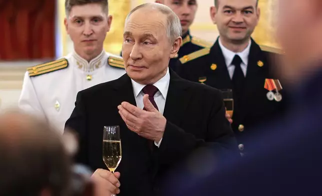 Russian President Vladimir Putin toasts with graduates of the country's highest military schools during a meeting at the Kremlin in Moscow, on Tuesday, June 23, 2026. (Gavriil Grigorov, Sputnik, Kremlin Pool Photo via AP)