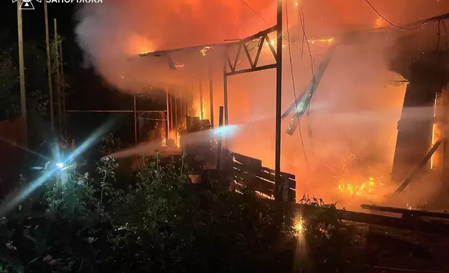 In this photo provided by the Ukrainian Emergency Service, emergency services personnel work to extinguish a fire following a Russian air attack in in Zaporizhzhia region, Ukraine, Monday, June 22, 2026. (Ukrainian Emergency Service via AP)