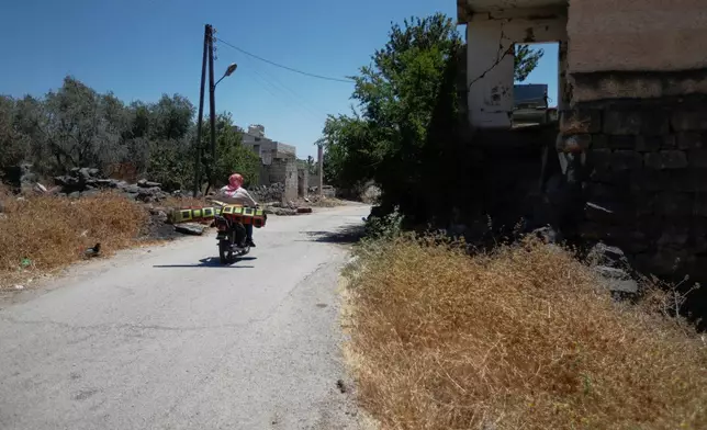 A man rides a motorcycle in the village of Abdin, Daraa province, Syria, Monday, June 29, 2026. (AP Photo/Omar Sanadiki)