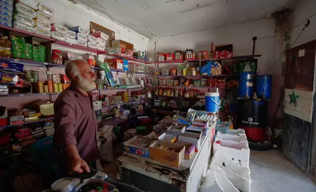 Mohammad al-Hassan stands inside his shop, stocked with food and household goods but empty of customers, in the village of Abdin, Daraa province, Syria, Monday, June 29, 2026. (AP Photo/Omar Sanadiki)