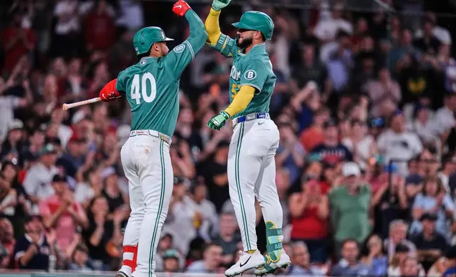 Boston Red Sox's Wilyer Abreu, right, celebrates with Willson Contreras (40) following his solo home run during the seventh inning of a baseball game against the Texas Rangers, Friday, June 12, 2026, in Boston. (AP Photo/Charles Krupa)