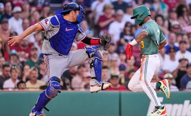 Boston Red Sox's Ceddanne Rafaela, right, beats a tag by Texas Rangers' Kyle Higashioka, left, to score on a sacrifice fly hit by Wilyer Abreu during the first inning of a baseball game, Friday, June 12, 2026, in Boston. (AP Photo/Charles Krupa)
