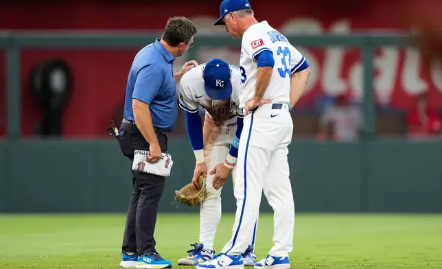 Kansas City Royals shortstop Bobby Witt Jr. talks to manager Matt Quatraro, right, and trainer Kyle Turner, left, after getting injured while fielding a single by St. Louis Cardinals' Jordan Walker during the fourth inning of a baseball game Thursday, June 18, 2026, in Kansas City, Mo. (AP Photo/Charlie Riedel)