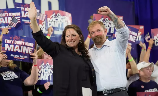 Democratic U.S. Senate candidate Graham Platner, right, and his wife Amy Gertner gesture to supporters during a primary election night watch party Tuesday, June 9, 2026, in Blue Hill, Maine. (AP Photo/Robert F. Bukaty)
