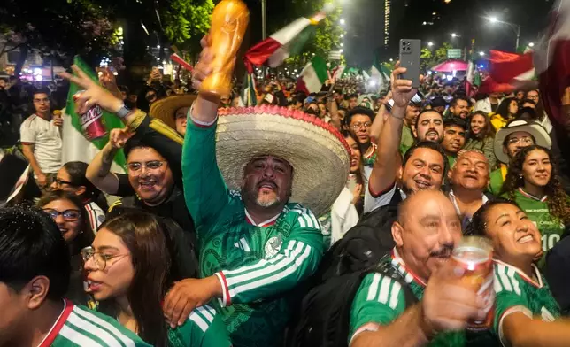 Mexican fans celebrate after beating South Korea during the World Cup Group A soccer match, at the Angel of Independence monument in Mexico City, Thursday, June 18, 2026. (AP Photo/Marco Ugarte)
