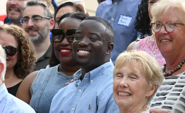 Adrian Boafo, center, a Maryland state delegate and candidate for U.S. Congress smiles for a photograph, which included all of U.S. Representative Steny Hoyer's staff over the years, at the "AmeriPac Bull Roast" Friday, June 12, 2026, in Mitchellville, Md. (AP Photo/Gail Burton)
