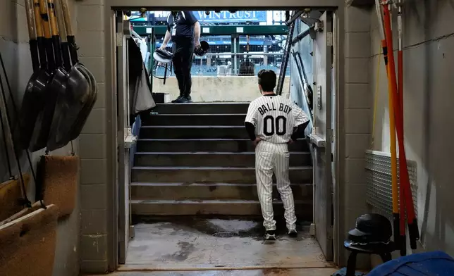 A Chicago White Sox ball boy looks to the field during a rain delay before a baseball game between the Atlanta Braves and the Chicago White Sox in Chicago, Thursday, June 11, 2026. (AP Photo/Nam Y. Huh)