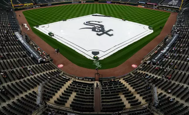 A tarp covers the infield during a rain delay before a baseball game between the Atlanta Braves and the Chicago White Sox in Chicago, Thursday, June 11, 2026. (AP Photo/Nam Y. Huh)