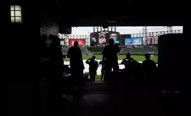 Baseball fans wait during a rain delay before a baseball game between the Atlanta Braves and the Chicago White Sox in Chicago, Thursday, June 11, 2026. (AP Photo/Nam Y. Huh)