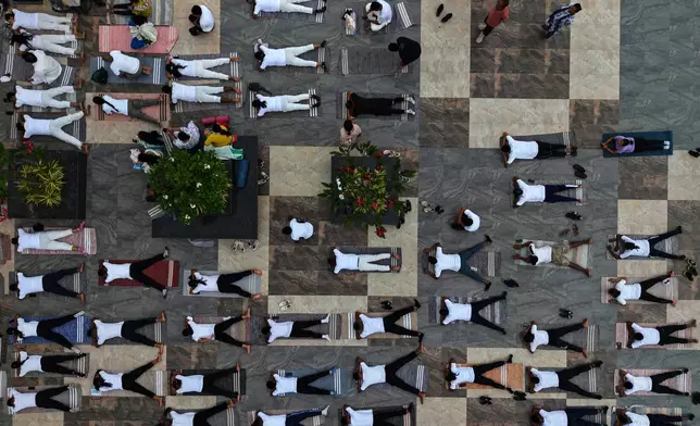 People perform yoga during an event to mark International Yoga Day along the river Brahmaputra in Guwahati, India, Sunday, June 21, 2026. (AP Photo/Anupam Nath)
