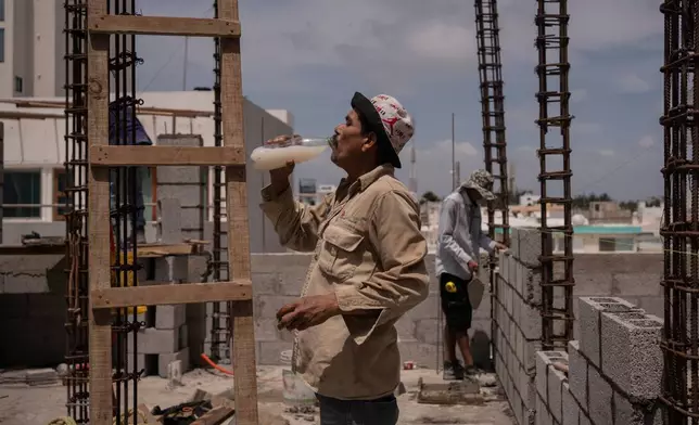 FILE - Jorge Moreno, a worker, drinks flavored water to cope with the heat wave during his workday at a construction site in Veracruz, Mexico, on June 17, 2024. (AP Photo/Felix Marquez, File)