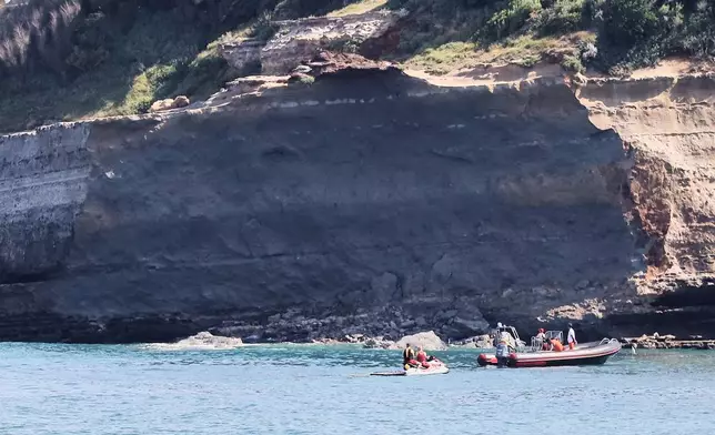 Rescue workers on boats search for a missing persona near a massive section of coastline which collapsed Wednesday evening, killing one diver and leaving another missing, in Biarritz, Thursday, June 25, 2026. (AP Photo/Yohan Bonnet)