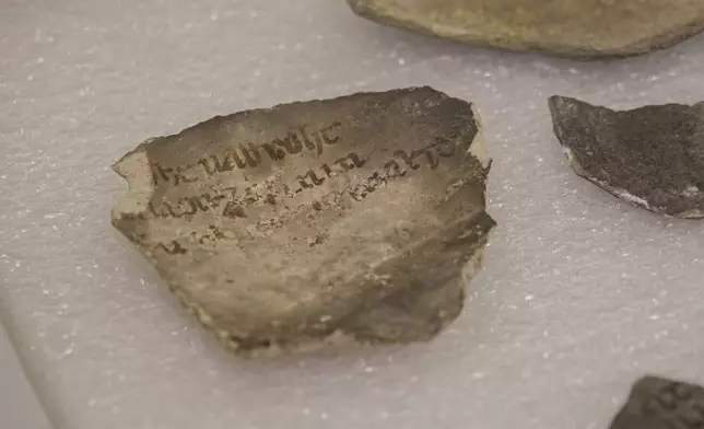 A fragment bearing an inscription is photographed among artifacts discovered during excavations outside Notre-Dame Cathedral in Paris, Monday, June 1, 2026. (AP Photo/Nicolas Garriga)