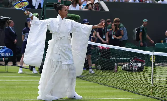 Naomi Osaka of Japan walks into the court to play against Elsa Jacquemot of France in their first round women's singles match at the Wimbledon Tennis Championships in London, Monday, June 29, 2026. (AP Photo/Maja Smiejkowska)