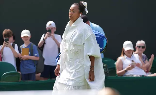 Naomi Osaka of Japan walks into the court to play against Elsa Jacquemot of France in their first round women's singles match at the Wimbledon Tennis Championships in London, Monday, June 29, 2026. (AP Photo/Maja Smiejkowska)
