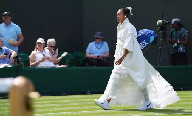 Naomi Osaka of Japan walks into the court to play against Elsa Jacquemot of France in their first round women's singles match at the Wimbledon Tennis Championships in London, Monday, June 29, 2026. (AP Photo/Maja Smiejkowska)
