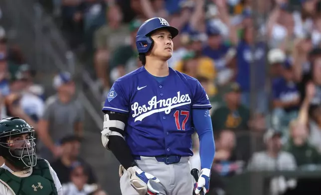 Los Angeles Dodgers' Shohei Ohtani, right, watches his three-run home run during the sixth inning of a baseball game against the Athletics, Monday, June 29, 2026, in West Sacramento, Calif. (AP Photo/Sara Nevis)