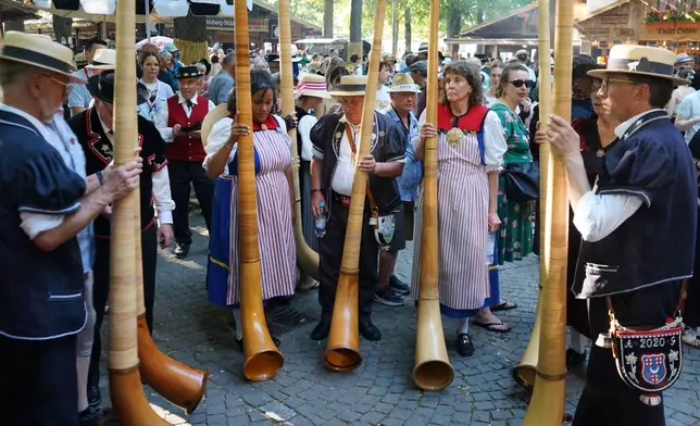 A group of Alpine Horn players stand at the Peters square in Basel, Switzerland, Saturday, June 27, 2026. (AP Photo/Jez Fielder)