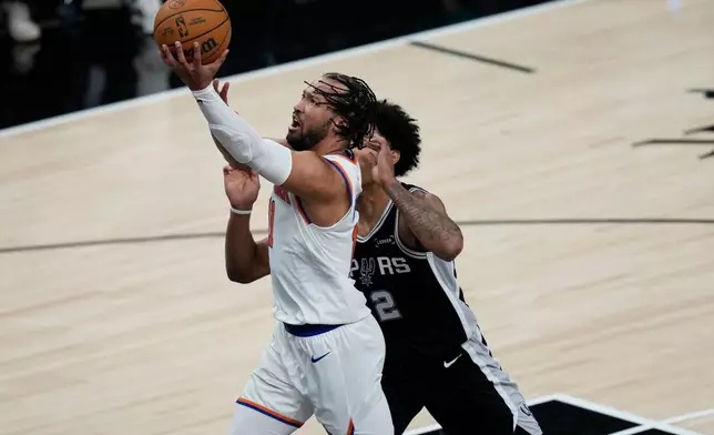 New York Knicks guard Jalen Brunson shoots past San Antonio Spurs guard Dylan Harper (2) during the first half of Game 1 of the NBA Finals basketball series, Wednesday, June 3, 2026, in San Antonio. (AP Photo/David J. Phillip)