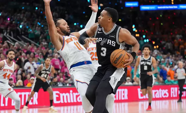 San Antonio Spurs forward Keldon Johnson (3) drives as New York Knicks guard Jalen Brunson (11) defends during the first half of Game 1 of the NBA Finals basketball series, Wednesday, June 3, 2026, in San Antonio. (AP Photo/Eric Gay)