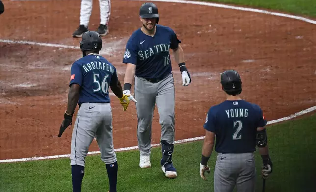 Seattle Mariners catcher Mitch Garver (18) is congratulated by Seattle Mariners left fielder Randy Arozarena (56) and Seattle Mariners second baseman Cole Young (2) after hitting a three run homer against the Baltimore Orioles in the fourth inning of a baseball game, Tuesday, June 9, 2026 in Baltimore.(AP Photo/Gail Burton)