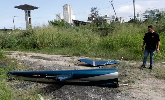 Aircraft debris lies near the site where two helicopters reportedly collided in midair and crashed into a car dealership parking lot in Rio de Janeiro, Brazil, Sunday, June 14, 2026. (AP Photo/Bruna Prado)
