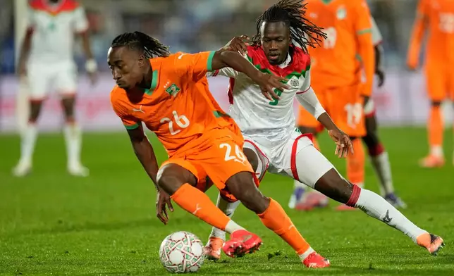 FILE - FILE - Ivory Coast's Yan Diomande, left, and Burkina Faso's Issa Kabore challenge during the Africa Cup of Nations best of 16 soccer match between Ivory Coast and Burkina Faso in Marrakech, Morocco, on Jan. 6, 2026. (AP Photo/Themba Hadebe, File)