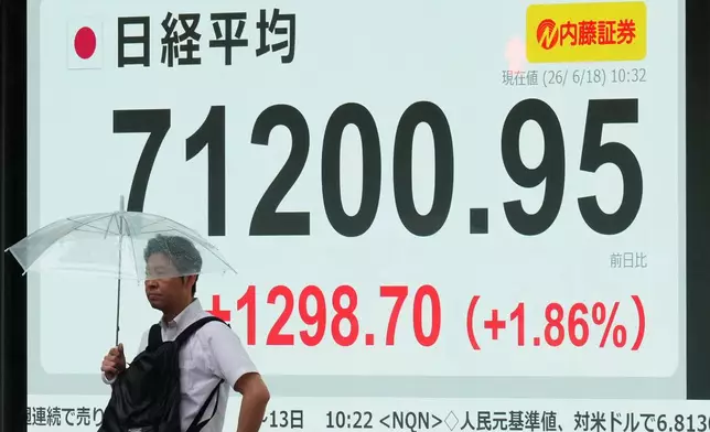 A man stands by a screen showing Japan's Nikkei 225 index at a securities firm in Tokyo, Thursday, June 18, 2026. (AP Photo/Hiro Komae)
