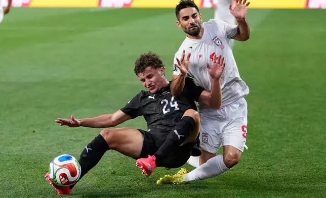 New Zealand's Callan Elliot (24) challenges for the ball with Iran's Milad Mohammadi (5) during the World Cup Group G soccer match between Iran and New Zealand in Inglewood, Calif., near Los Angeles, Monday, June 15, 2026. (AP Photo/Mark J. Terrill)