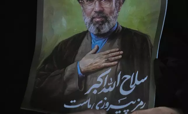 A woman holds a poster of the Iranian Supreme Leader Ayatollah Mojtaba Khamenei during a pro-government gathering at Islamic Revolution Square in Tehran, Iran, Saturday, May 30, 2026. (AP Photo/Vahid Salemi)