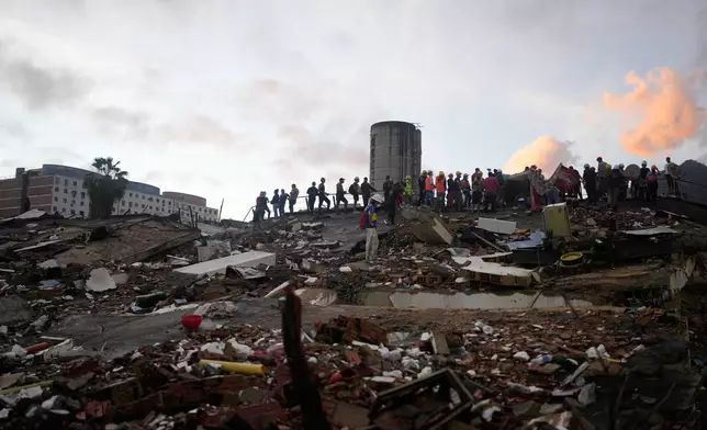 Rescuers search through the rubble of buildings that collapsed in the earthquakes in La Guaira, Venezuela, Tuesday, June 30, 2026. (AP Photo/Ariana Cubillos)