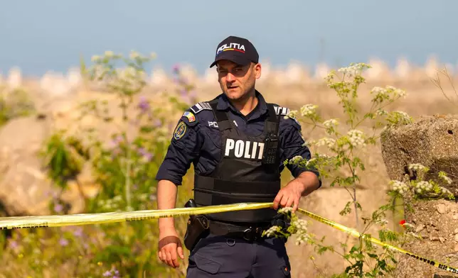 A Romanian Police officer secures an entrance in the vicinity of a damaged warehouse following the explosion of a maritime drone in the Black Sea port of Constanta, Romania, Friday, June 5, 2026. (AP Photo/Vadim Ghirda)