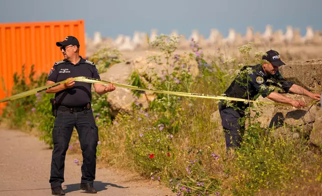 Romanian Border Police officers secure an entrance in the vicinity of a damaged warehouse following the explosion of a maritime drone in the Black Sea port of Constanta, Romania, Friday, June 5, 2026. (AP Photo/Vadim Ghirda)