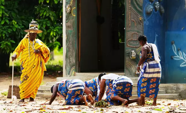 Daagbo Hounon Houna II, the Supreme Spiritual Voodoo Chief, left, is greeted by priestesses before an interview with The Associated Press In Ouidah, Benin, May 14, 2026. (AP Photo/Sunday Alamba)