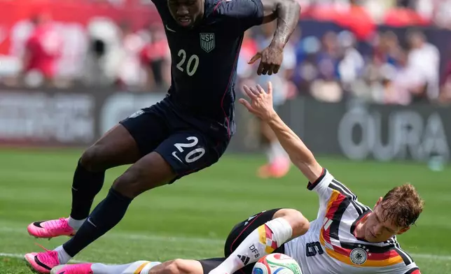 Germany midfielder Joshua Kimmich, right, controls the ball under United States forward Folarin Balogun during the first half of an international friendly soccer match in Chicago, Saturday, June 6, 2026. (AP Photo/Nam Y. Huh)
