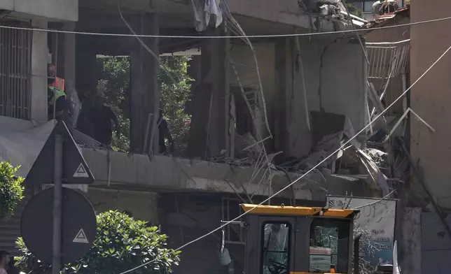 People gather at the site where an Israeli airstrike struck an apartment in Dahiyeh, Beirut's southern suburbs, Lebanon, Sunday, June 14, 2026. (AP Photo/Bilal Hussein)