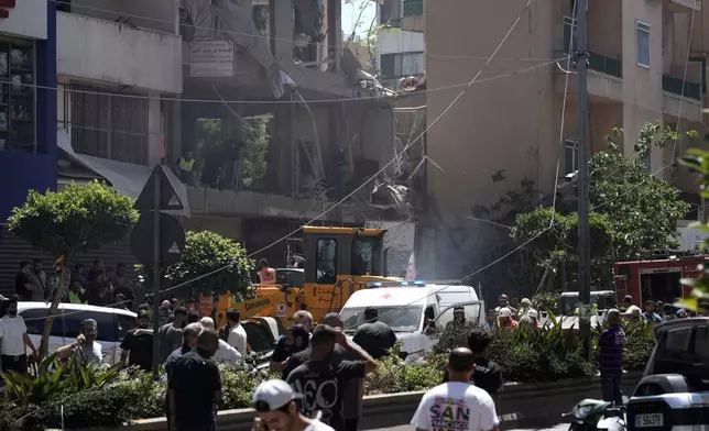 People gather at the site of an Israeli airstrike that struck an apartment in Dahiyeh, Beirut's southern suburbs, Lebanon, Sunday, June 14, 2026. (AP Photo/Bilal Hussein)