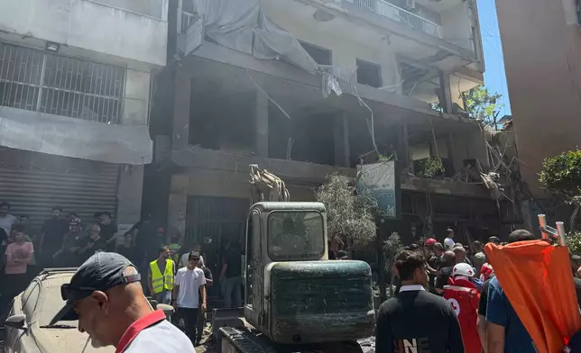 People gather at the site of an Israeli airstrike that struck an apartment in Dahiyeh, Beirut's southern suburbs, Lebanon, Sunday, June 14, 2026. (AP Photo/Bilal Hussein)