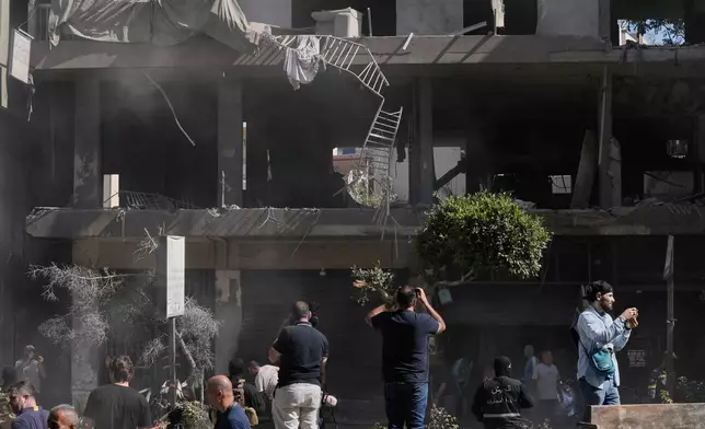 People gather at the site of an Israeli airstrike that struck an apartment in Dahiyeh, Beirut's southern suburbs, Lebanon, Sunday, June 14, 2026. (AP Photo/Bilal Hussein)
