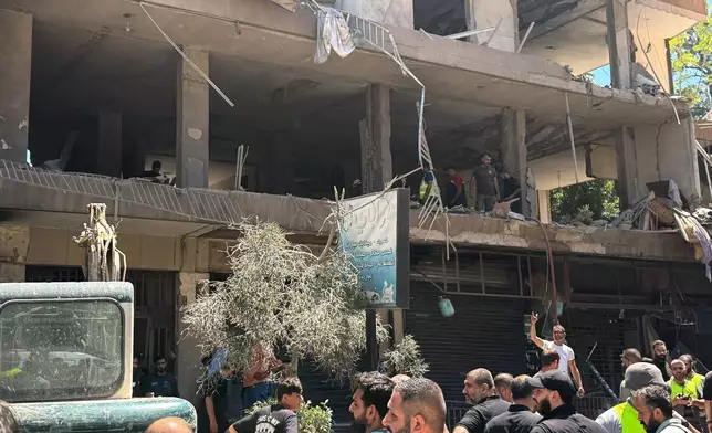 People gather at the site of an Israeli airstrike that struck an apartment in Dahiyeh, Beirut's southern suburbs, Lebanon, Sunday, June 14, 2026. (AP Photo/Bilal Hussein)