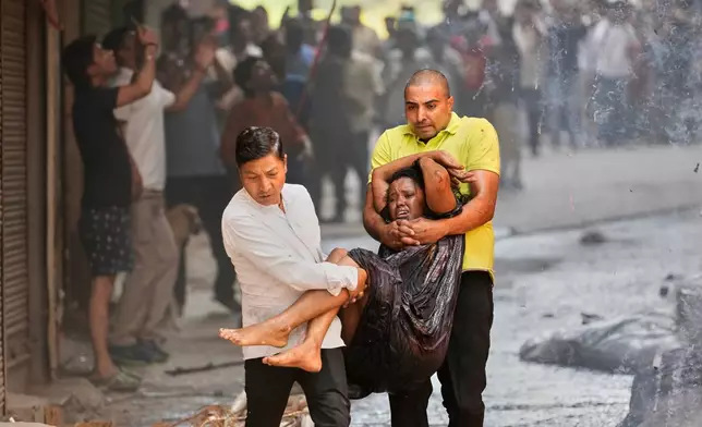 Local people rescue a foreign national from a hotel fire in New Delhi, India, Wednesday, June 3, 2026. (AP Photo/Manish Swarup)