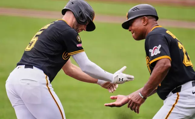 Pittsburgh Pirates' Brandon Lowe, left, is greeted by third base coach Tony Beasley as he rounds third base after hitting a solo home run off Seattle Mariners pitcher Bryce Miller during the first inning of a baseball game in Pittsburgh, Thursday, June 25, 2026. (AP Photo/Gene J. Puskar)