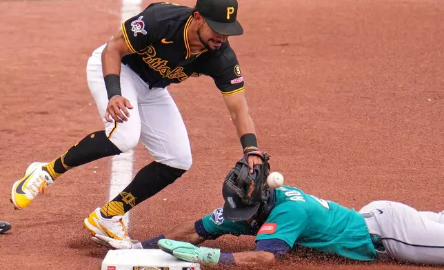 Seattle Mariners' Julio Rodríguez, right, slides safely into third base with a stolen base as the ball gets away from Pittsburgh Pirates third baseman Nick Gonzales during the fourth inning of a baseball game in Pittsburgh, Thursday, June 25, 2026. (AP Photo/Gene J. Puskar)